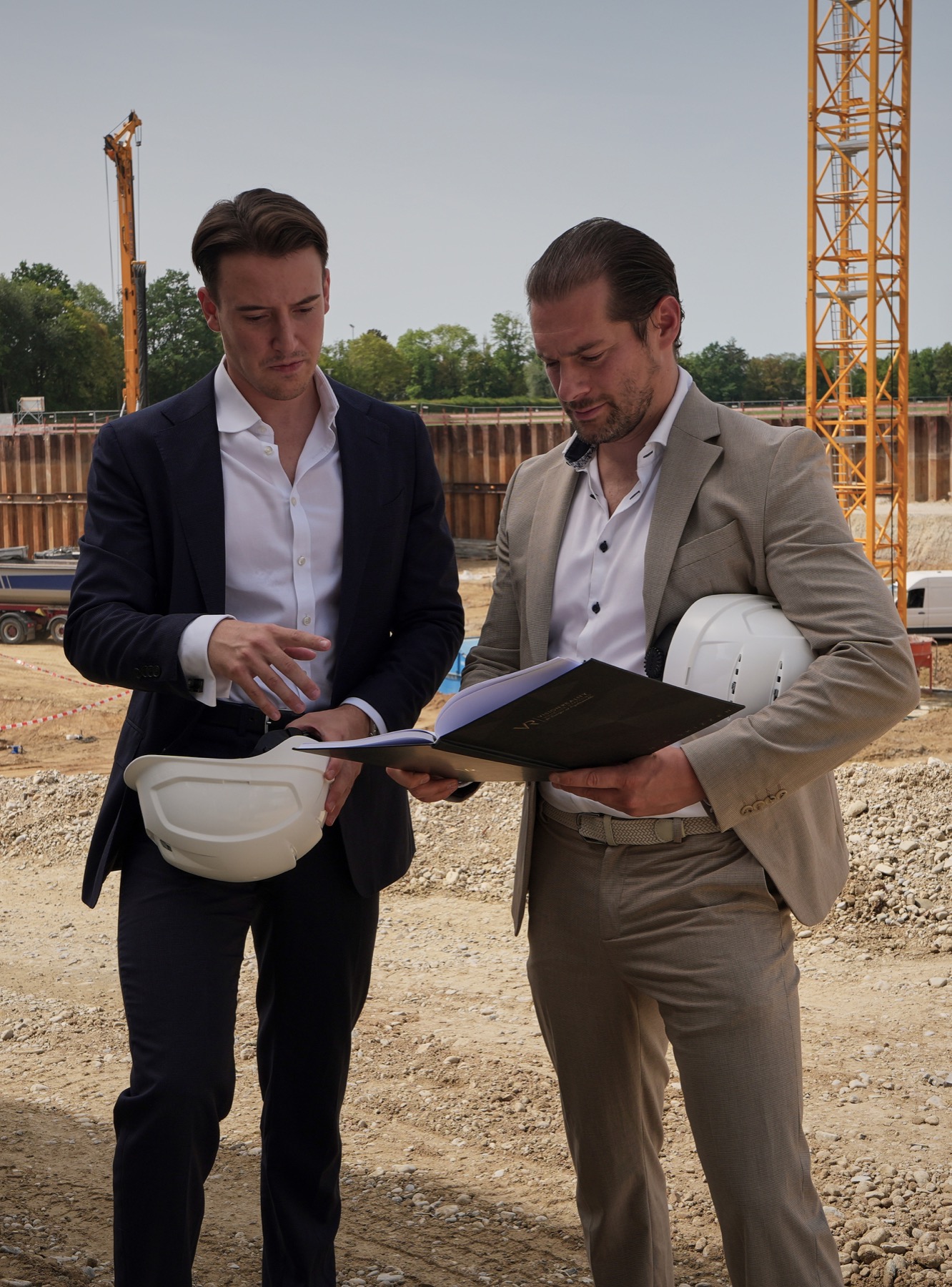 Jakob Käppner und Maximilian Böswald im Austausch mit Bauträger-Partnern auf der Baustelle